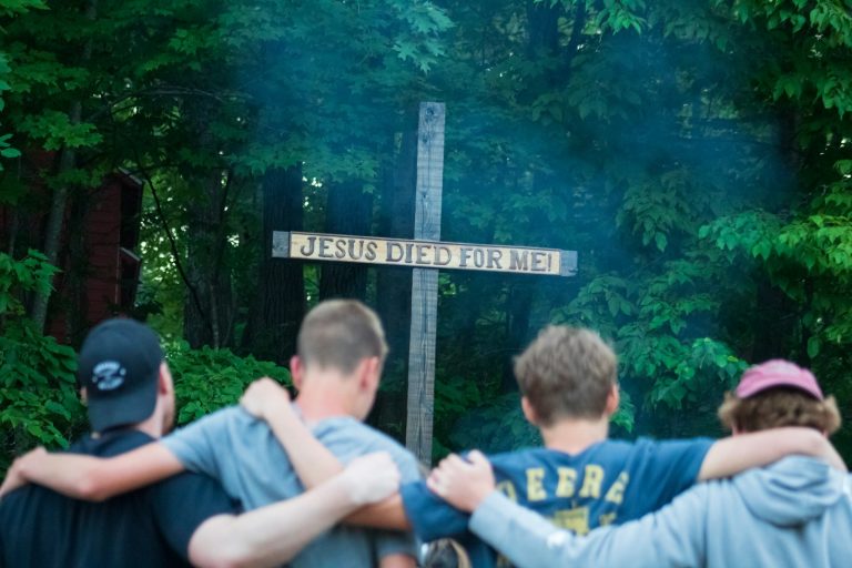 A group of people standing around a cross
